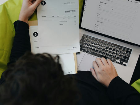 Person analysiert Haushaltskosten am Laptop als Symbol für steigende Lebenshaltungskosten und die Suche nach zusätzlichem Einkommen über VestChance.